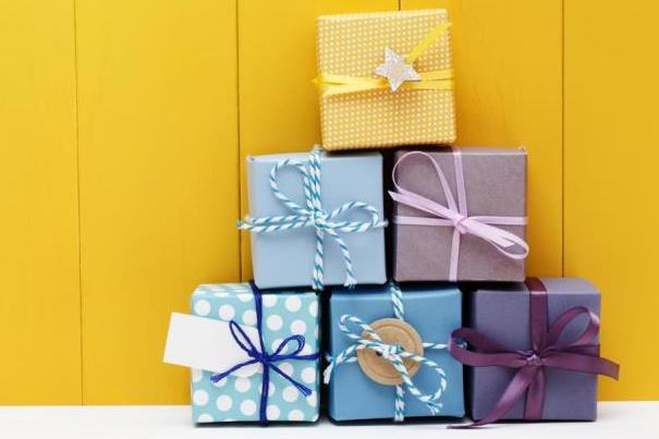 Stack of colourful gift boxes arranged in a pyramid shape against a yellow background